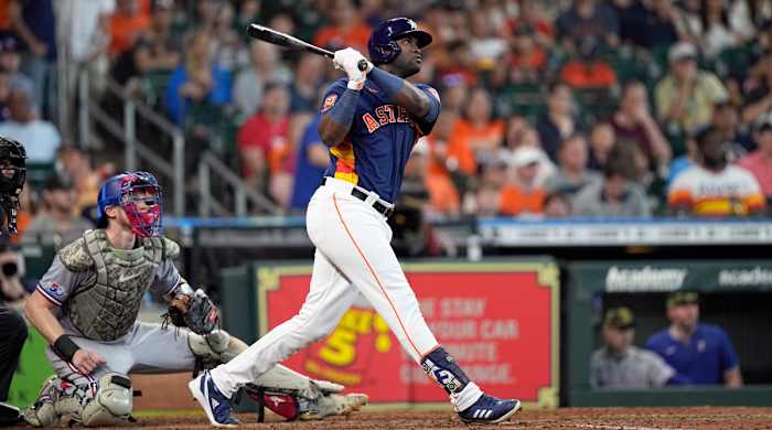 Houston Astros’ Yordan Alvarez, right, hits an RBI-double as Texas Rangers catcher Sam Huff watches during the fifth inning of a baseball game Sunday, May 22, 2022, in Houston.